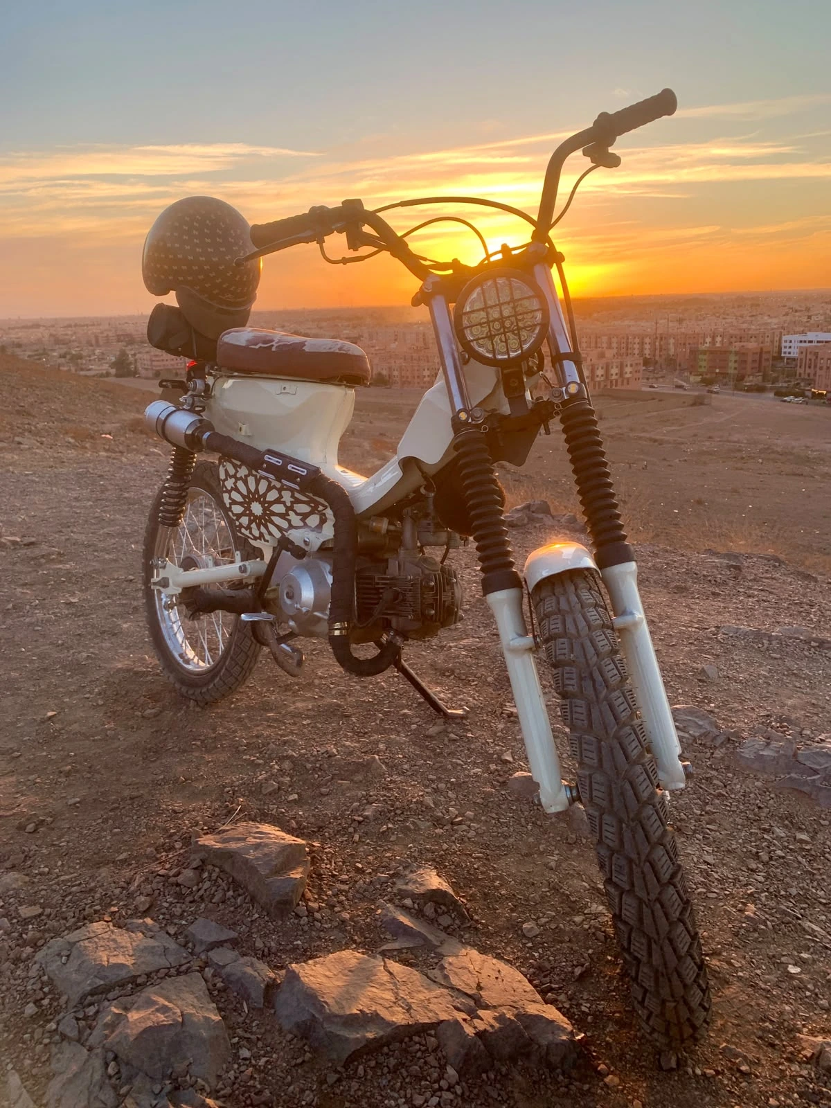 Mouad El Baraka custom Super Cub C90 motorcycle at sunset overlooking Marrakech