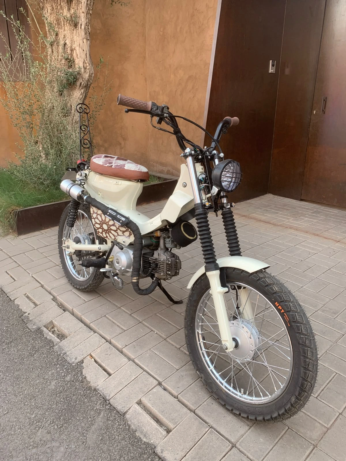 Front three-quarter view of the Mouad El Baraka custom motorcycle beside Moroccan architecture