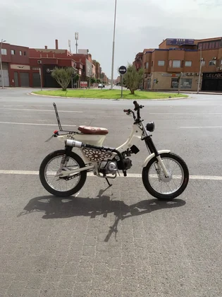 Mouad El Baraka Super Cub C90 custom motorcycle side profile on a Marrakech street thumbnail
