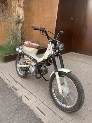 Front three-quarter view of the Mouad El Baraka custom motorcycle beside Moroccan architecture thumbnail