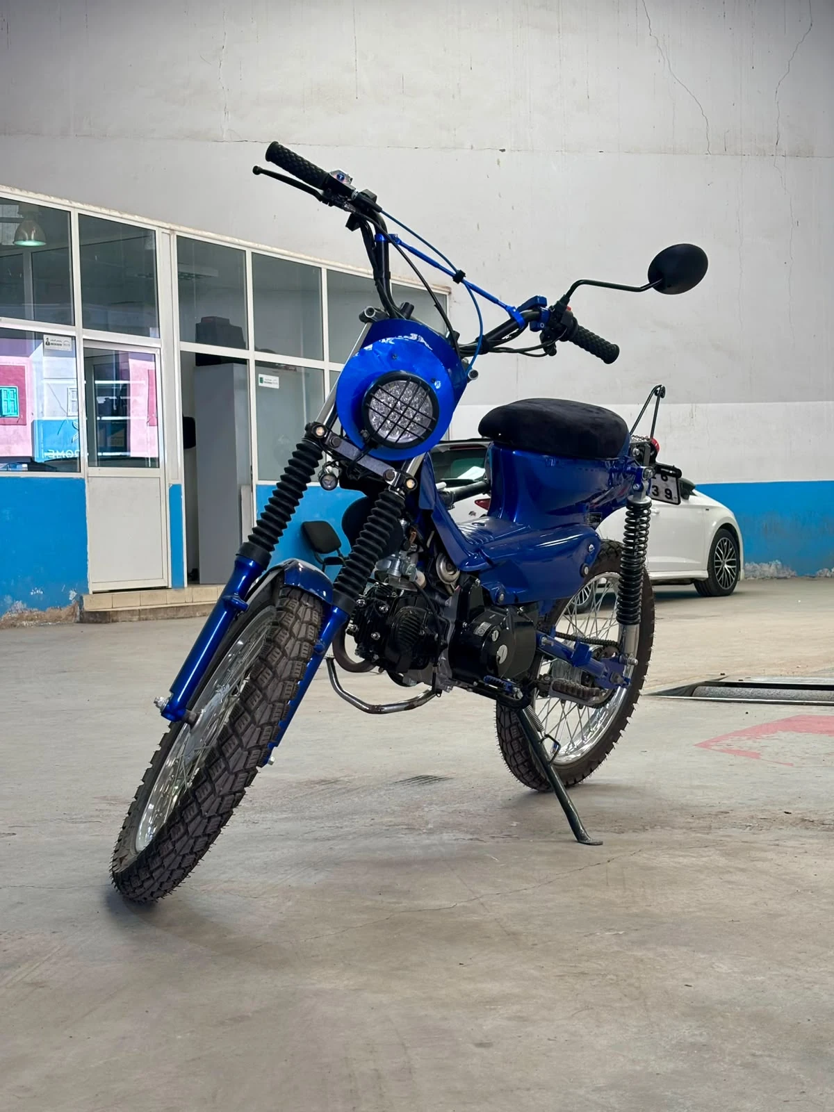 Sidi Bel Abbes custom blue motorcycle angled front view inside the BCE workshop