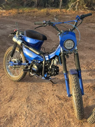 Sidi Bel Abbes custom blue motorcycle front three-quarter view on desert terrain thumbnail