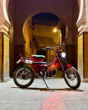 Sidi Youssef Ben Ali custom red motorcycle under a Marrakech archway at night thumbnail