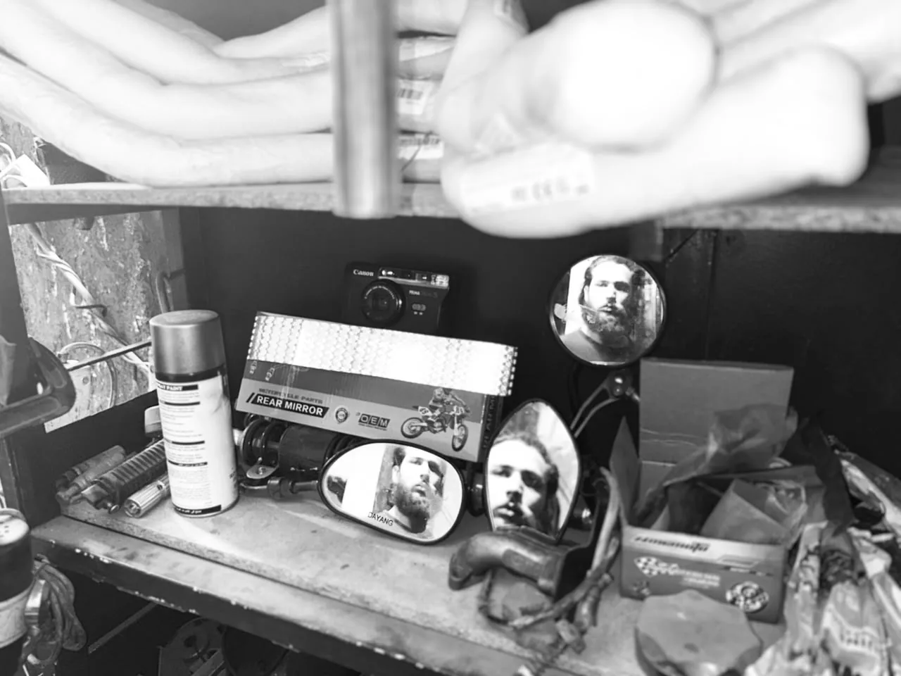 Black and white still life of workshop mirrors and tools reflecting the creator