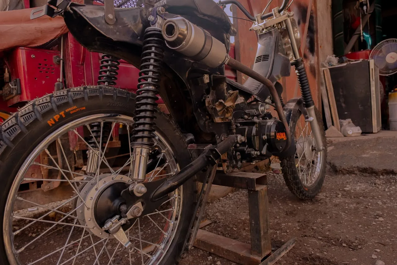 Three-quarter rear view of a custom motorcycle outside the workshop