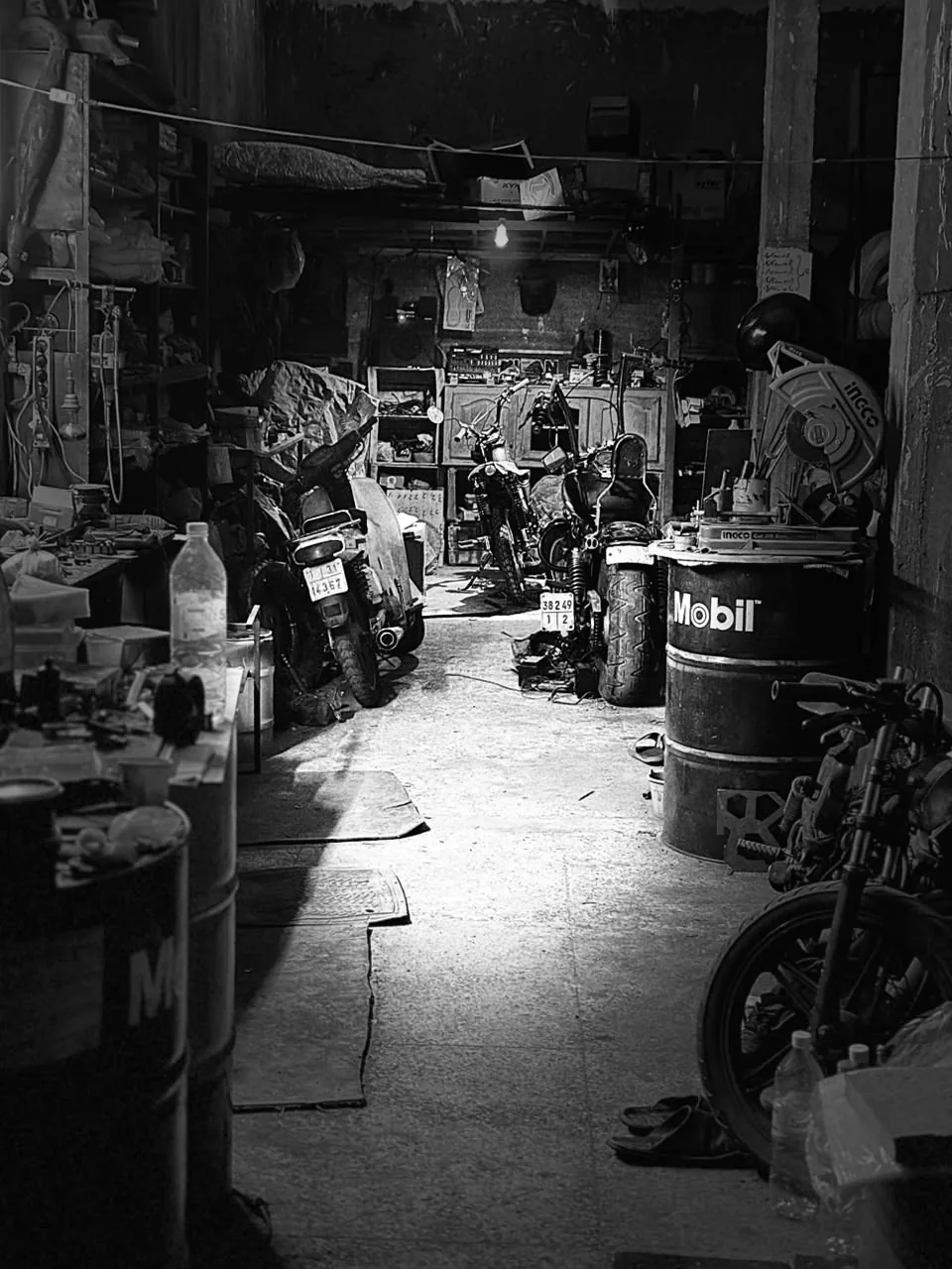 Wide black and white view of the BCE workshop and motorcycles in progress