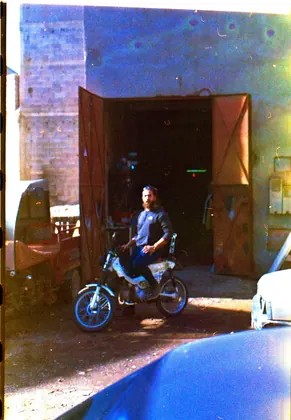 Archival image of Mouad El Baraka seated on an early custom motorcycle in front of the workshop thumbnail