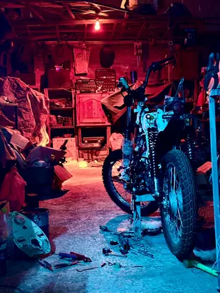 Custom motorcycle project inside the BCE workshop under red and blue lighting thumbnail