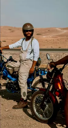 Portrait of the creator on a blue motorcycle in the desert landscape thumbnail