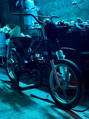 Blue-lit close-up of a custom motorcycle build in progress thumbnail