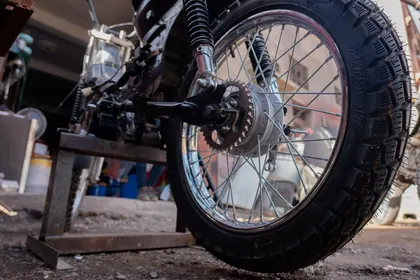 Low-angle detail of a rear wheel and suspension outside the workshop thumbnail